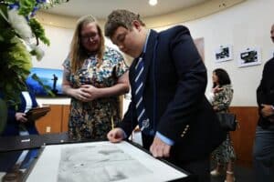 Luke signing finished art project on graduation day at Oxford Academy